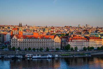 Evening sunlight fills Prague Old Town, Czech Republic, with the Vltava River and cruise boats along its banks- 1
