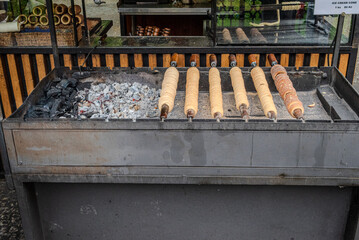 Traditional street-side stove baking Trdelník, a spiral-shaped pastry, in Prague Old Town, Czech Republic.