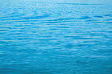 Calm river surface with gentle ripples reflecting blue sky on a sunny day