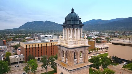 Beautiful cupola and columns of the clock tower in Colorado Springs City Hall. Scenery of American city with mountain range at backdrop. - Powered by Adobe