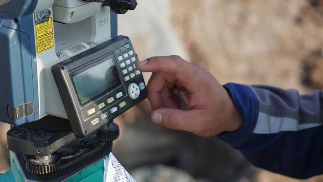 Surveyor using electronic theodolite total station device. Clip