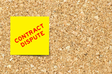 Yellow note paper with word contract dispute on cork board background with copy space