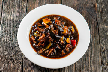 Frying eggplant with bell pepper in soy sauce. Chinese cuisine. Asian food. Food concept.
