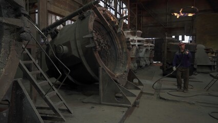 Foundry workers pouring molten metal into molds. Stock clip