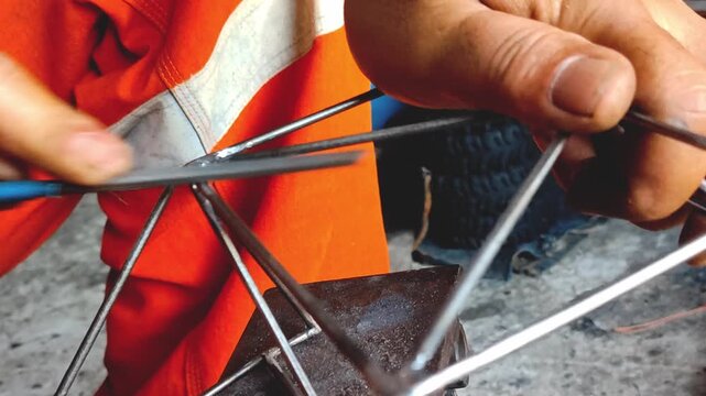 Metal craftsman's hand is smoothing an iron corner with a metal file