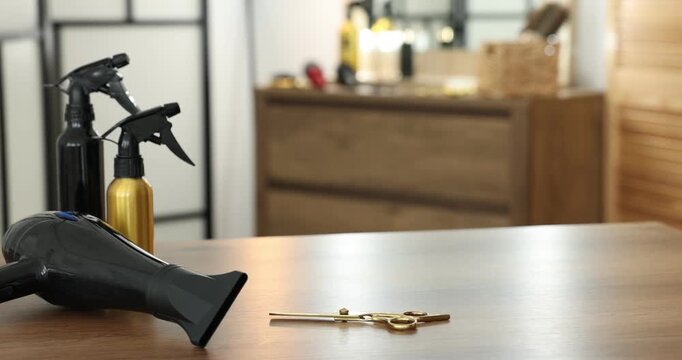 Hairdresser putting scissors on wooden table in salon, closeup - Powered by Adobe