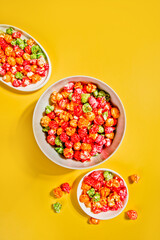 Bowls of colorful cereal corn rings on yellow table. Breakfast concept.