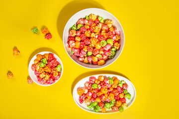 Bowls of colorful cereal corn rings on yellow table. Breakfast concept.