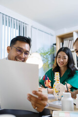 A doctor and a nurse are examining a model of a heart. The doctor is explaining the anatomy of the heart to the nurse
