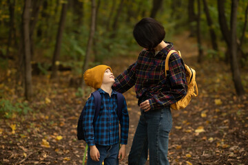 Fototapeta premium Mother with kid child boy son hiking in autumn forest.