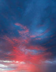 Dramatic sky with storm clouds illuminated by red sunset or sunrise. Vivid colorful cloudscape for nature banner or weather background. Bright sunset or sunrise light.