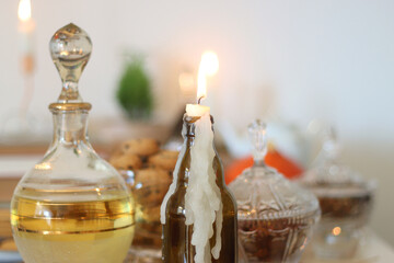Lit candles, cookies, chocolate, nuts, tea, wine, pumpkins, books, reading glasses and autumn leaves on the table. Autumnal hygge at home. Selective focus.