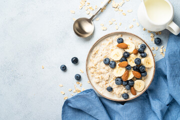 Oatmeal porridge with milk, bananas and blueberries.