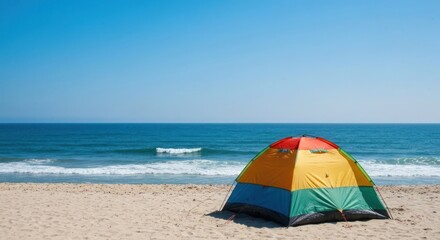 Colorful tent on a sandy beach, ocean in the background.  Bright, sunny day