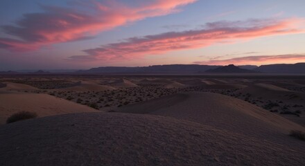 Desert landscape at sunset.  Pink clouds over dunes