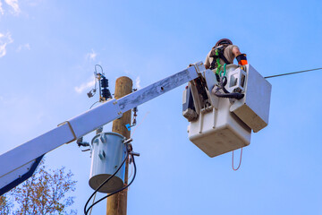 Worker is elevated in bucket truck to service power lines, ensuring safe reliable electricity delivery.
