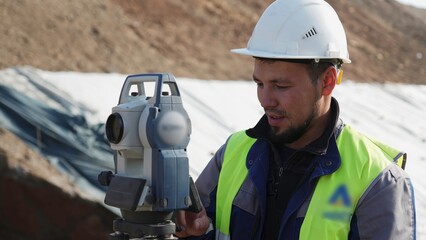 Surveyor using theodolite on construction site. Clip