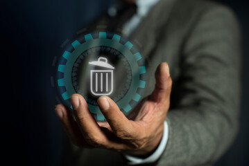Man hand holding the delete button on virtual screen. Recycle bin