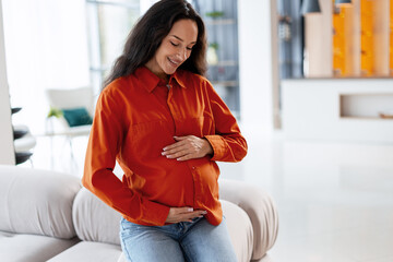 Pregnant woman embracing baby bump with happiness