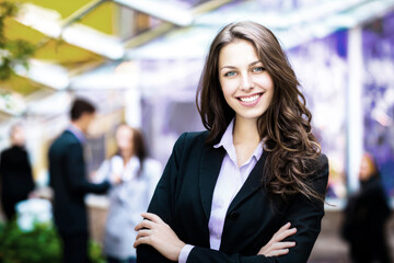 Naklejka premium Confident young caucasian female professional smiling outdoors at business event.
