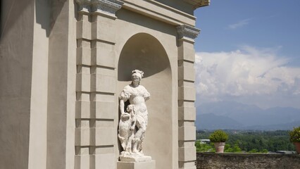 Obraz premium Elegant white statue adorning italian villa with scenic mountain view. Action