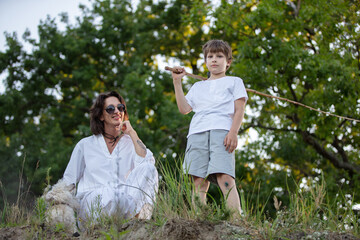 A woman and a child, enjoying adventures in the open air together in a solar rural area, communicating with nature.