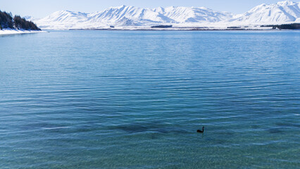 Tranquil mountain landscape with snowy peaks and serene blue lake. Lake Tekapo, New Zealand