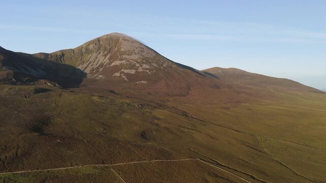 Amazing 4K aerial video of flying above and around Most Famous mountain in Ireland - Croagh Patrick in windy weather, with moving fog and clouds with breathtaking views around, Westport, Ireland