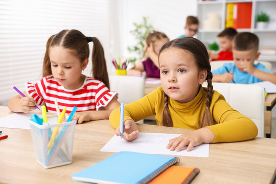 Children at wooden desks during art lesson in elementary school