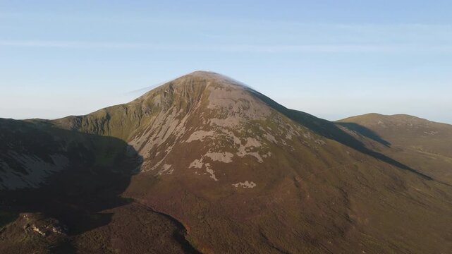 Amazing 4K aerial video of flying above and around Most Famous mountain in Ireland - Croagh Patrick in windy weather, with moving fog and clouds with breathtaking views around, Westport, Ireland