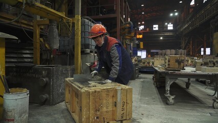 Foundry worker preparing sand mold. Stock clip