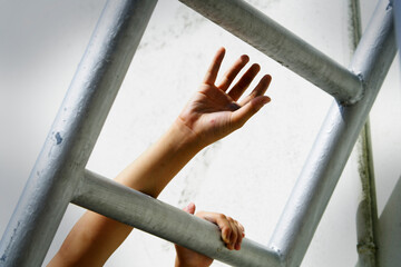 Hand Reaching for Freedom Beyond Steel Bars in Urban Setting
