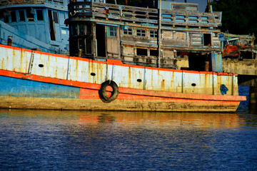 Rustic Fishing Boat Reflections in Calm Water at Sunset