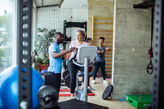 Senior woman exercising in the gym with her personal trainer