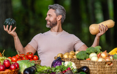 Greengrocer harvesting. Autumn vegetable harvest. Farmer food market. Pumpkin for Halloween. Man farmer choose vegetable harvest. Organic food gourd. Greengrocer man Halloween pumpkin growing