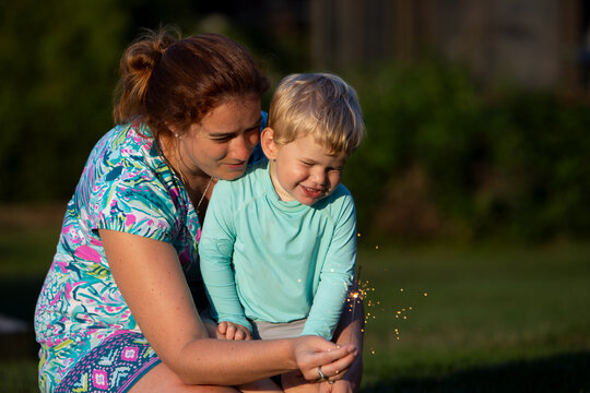 Mother and young child with a lit sparkler