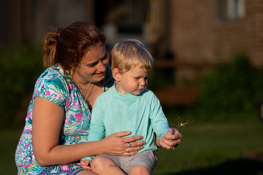 Child with a sparkler and his mother