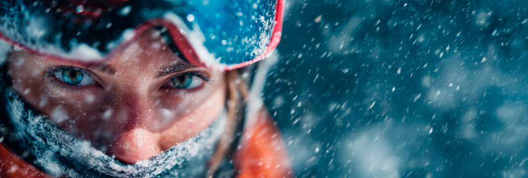 Winter athlete wearing ski goggles in a snowstorm with copy space: Winter Olympics and extreme sports concept