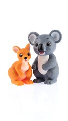 A small, adorable orange kangaroo figurine stands next to a cuddly gray koala bear figure, on a plain white background. Both are smiling