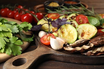 Vegetarian barbeque. Tasty grilled vegetables served on wooden table, closeup