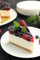 Piece of delicious cheesecake with berries and mint on table, closeup