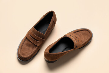 Pair of stylish chamois leather shoes on beige background, top view