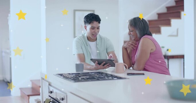 Grandson tapping tablet and showing messages using tech in kitchen while grandma reliving memories
