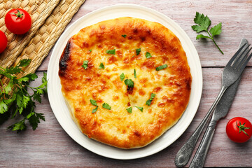 Delicious Megrelian khachapuri with parsley served on wooden table, flat lay