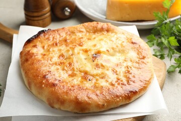 Delicious Megrelian khachapuri with ingredients on grey table, closeup