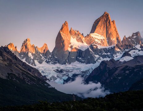 Jagged, snow-capped peaks kissed by golden morning light, with valley below - Powered by Adobe