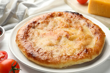 Delicious Megrelian khachapuri and products on white wooden table, closeup
