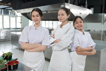 Cooking, Kitchen. Portrait of young female chef wearing white apron in kitchen at restaurant