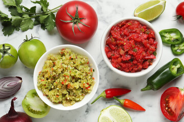 Tasty salsa in bowl and ingredients on white marble table, flat lay