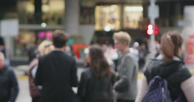 A busy pedestrian street in a city with a blurred crowd of people walking, showcasing urban life dynamics. Slow motion.